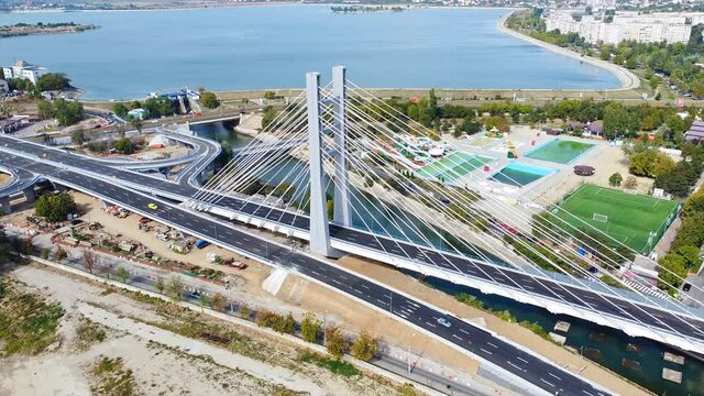 Ciurel passage, bridge over a river with moving cars, recreational complex, lake. View from the drone. Bucharest, Romania