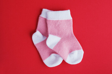 Obraz na płótnie Canvas pair of pastel pink socks on red background