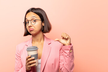 young hispanic woman feeling proud, arrogant and confident, looking satisfied and successful,...