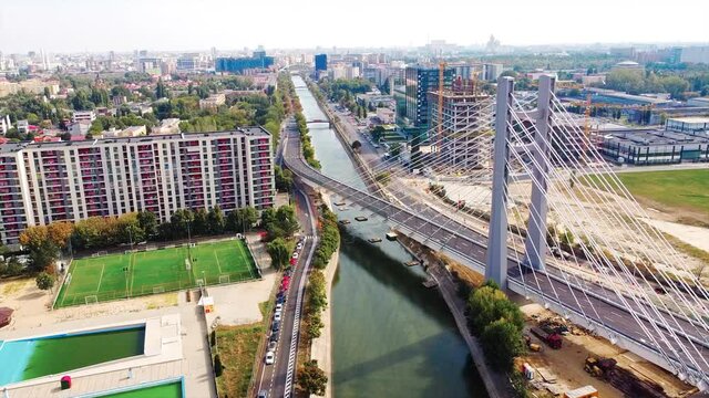 Ciurel passage, bridge over a river with moving cars, recreational complex, lake. View from the drone. Bucharest, Romania
