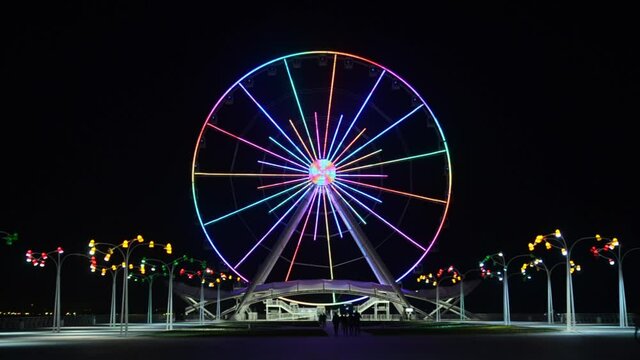 Ferris wheel on the boulevard in Baku, near the Caspian Sea, shot in the evening on a long exposure, with color lighting effects. Azerbaijan.
