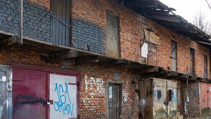 Old rusty iron gate with red brick wall loft warehouse. Slum concept. Background for design. Space for text.