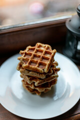 A big stack of Belgian sourdough waffles in a white plate