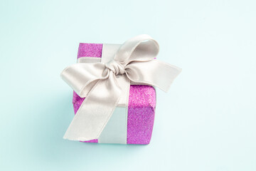front view cute little present tied with bow on blue background xmas gift color new year photo