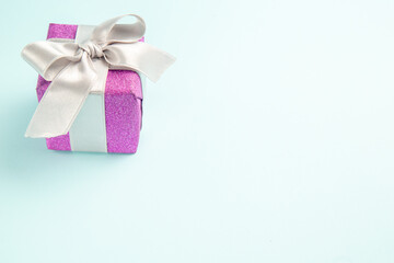 front view cute little present tied with bow on a blue background xmas gift color new year photo