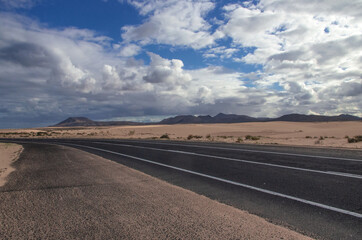 empty strip of asphalt between sand dunes in Corralejo National Park.Fuerteventura, Canary Islands, Spain