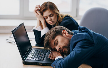 Work colleagues asleep at the desk in front of the laptop fatigue rest