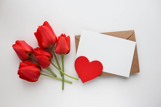 Happy Valentine's Day greeting card. bouquet of red tulips on white background, red heart and space for text