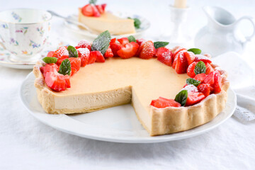 Traditional German cheesecake with strawberry fruits served as close-up on a classic design plate with tablecloth