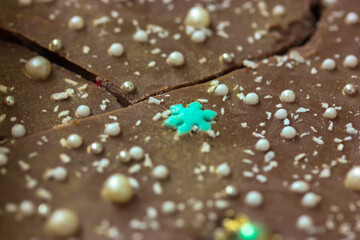 Handmade milk chocolate bars decorated in New Year's style - with snowflakes and white pearl beads. Sweet gift for Christmas