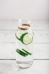 Infused water with sliced cucumber in bottle