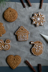 Gingerbread cookies on baking paper on a gray background. Homemade baking. Christmas holidays concept. Vertical orientation.