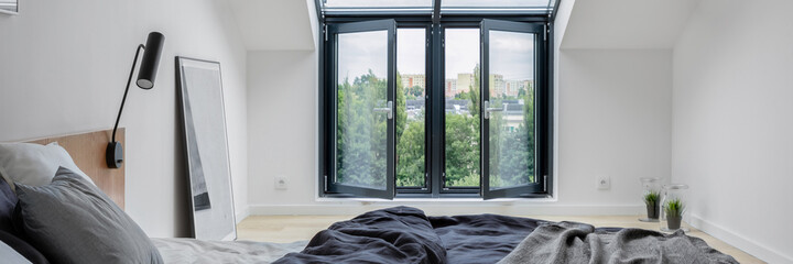 Fototapeta na wymiar Attic bedroom with big window, panorama