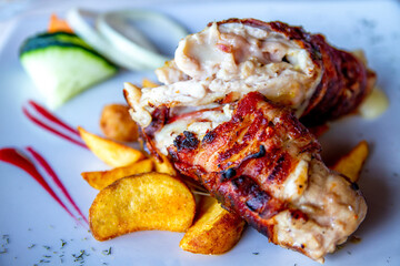 Tasty chicken meat with potatoes and vegetables. Roasted chicken meat in the white plate.