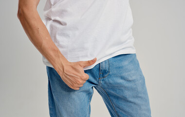 a man in jeans and a t-shirt shows a thumb up below the belt