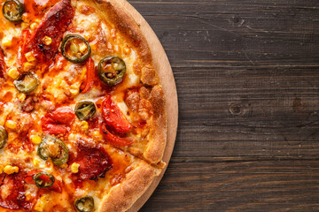 Fresh pizza with tomato sauce, black olives, mozzarella cheese, ham on wooden table closeup. Space for text or copy space. Pizza menu. Restaurant menu advertise