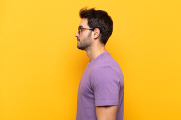 young handsome man on profile view looking to copy space ahead, thinking, imagining or daydreaming