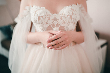 Obraz na płótnie Canvas the bride's hands on the dress close-up