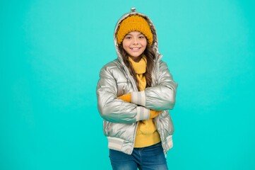 happy kid in silver puffer jacket and knitwear get warm in winter ready for activity on holidays, xmas vacation