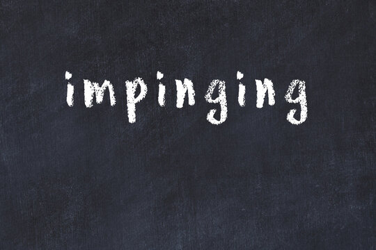 College chalk desk with the word impinging written on in