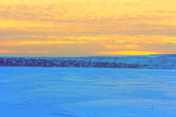 Fototapeta na wymiar Orange sky over the frozen lake