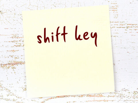Yellow sheet of paper with word shift key. Reminder concept
