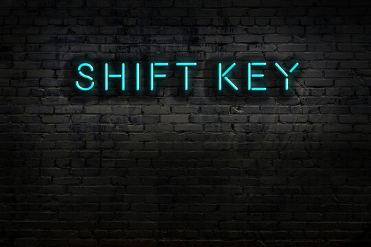 Night view of neon sign on brick wall with inscription shift key