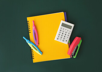 Flat lay composition with different school stationery on green chalkboard. Back to school © New Africa