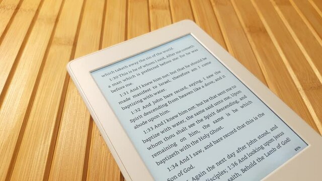 Bible Page on E-ink Ebook Reader Flipped by Woman