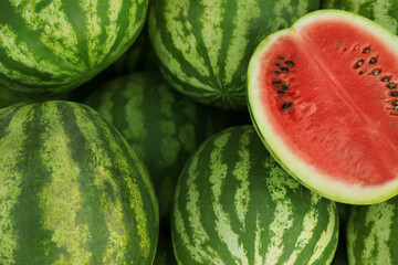 Delicious whole and cut watermelons as background, closeup