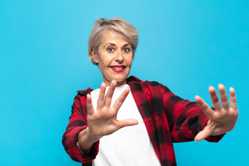 middle age woman feeling terrified, backing off and screaming in horror and panic, reacting to a...