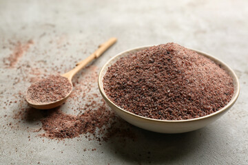 Ground black salt in bowl on grey table