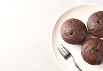 Delicious chocolate cupcakes on white table, top view. Space for text