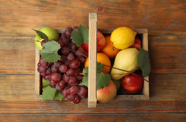Crate with different fruits on wooden table, top view