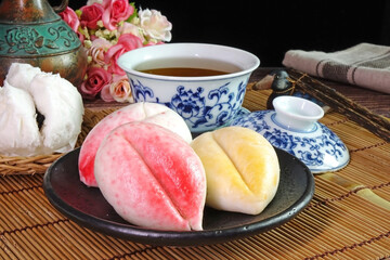 Chinese steamed buns, variety of Traditional Chinese steamed stuffed buns, shaped in peach fruit and traditional style shaped served with Chinese tea