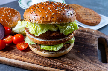 Lunch or dinner with tasty vegetarian hamburgers made from plant based grilled burgers, fresh bakes buns and organic vegetables
