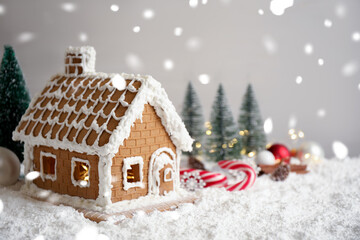 Beautiful gingerbread house decorated with icing on snow, space for text