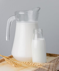 A jug and bottle of  fresh milk glass on wooden crate box..Raw milk is high in calcium and protein to drink for all ages..Milk consumption nutritious and healthy dairy products concept.