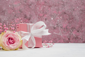 Gift box with flowers on pink Valentine's Day background. Copyspace. Rose and gift