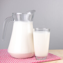 A jug and bottle of milk glass on a wooden table on background..Raw milk is high in calcium and protein to drink for all ages..Milk consumption nutritious and healthy dairy products concept..