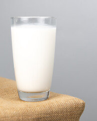 A glass of fresh  milk on sackcloth for a background..Raw milk is high in calcium and protein to drink for all ages..Milk consumption nutritious and healthy dairy products concept.