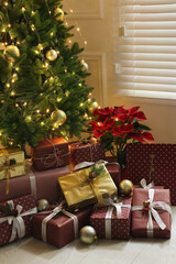 Many different gifts under Christmas tree indoors