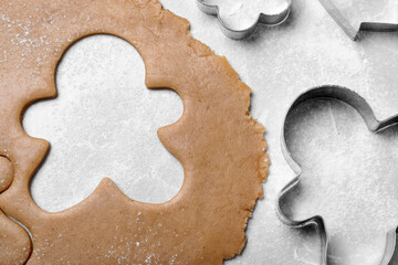 Making homemade Christmas cookies. Dough for gingerbread man and cutters on light grey table, flat lay