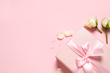 Elegant gift box and beautiful flowers on pink background, flat lay. Space for text
