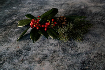Seasonal (winter) red berries and green leaves, conifers  -- evoking feelings of joy and comfort. 