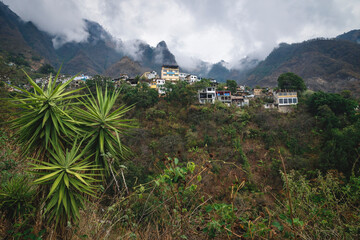 Fototapeta na wymiar View up to steep mountains with palm trees with the village of Santa Cruz la Laguna, Guatemala