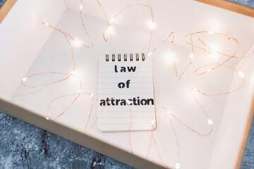 law of attraction and positive mindset, box as metaphor of the mind with Law Of Attraction notepad surrounded by fairy lights
