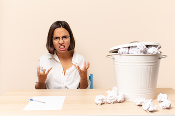 young latin woman looking angry, annoyed and frustrated screaming wtf or what’s wrong with you