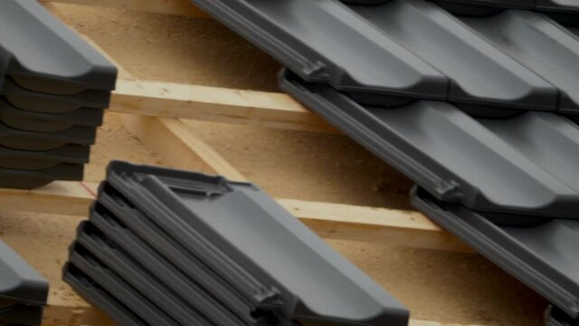 Close up pan shot showing black roof shingles during construction site. Build a new modern residential house.