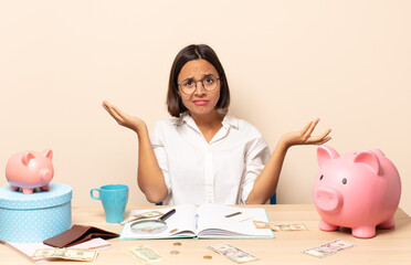 young latin woman looking puzzled, confused and stressed, wondering between different options,...